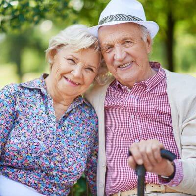  senior couple sitting in the park and looking at camera