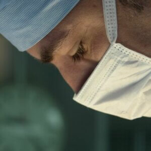 close up of a male eye surgeon’s face during an operation