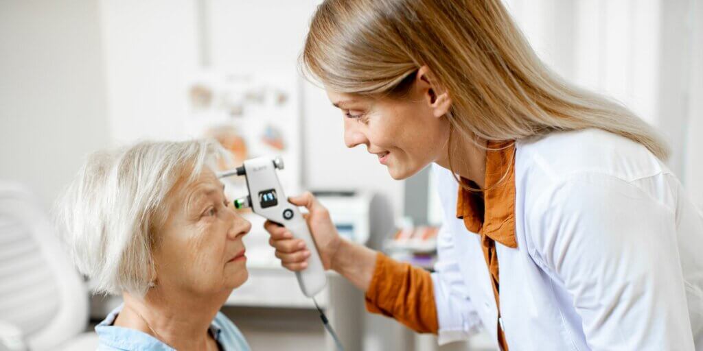 younger female ophthalmologist checks an older female patient’s vision
