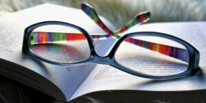cheap reading glasses laying on an open book