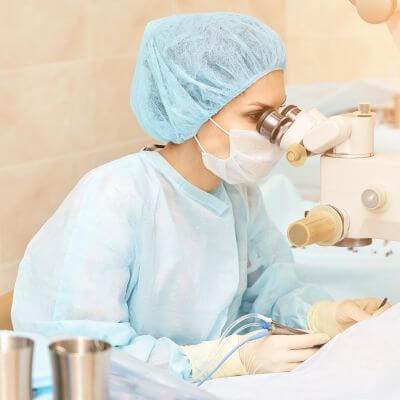 female ophthalmologist performing eye surgery